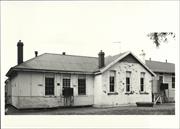 Front elevation of school contrasting original stonework to later wooden additio