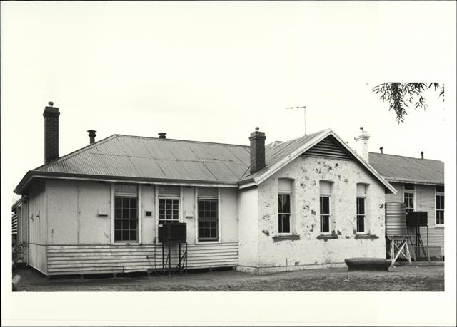 Front elevation of school contrasting original stonework to later wooden additio