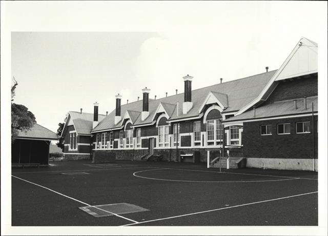 Angled rear elevation of building from across netball court