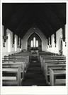 Interior view from entrance showing altar in background and pews in foreground