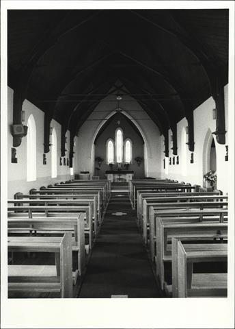 Interior view from entrance showing altar in background and pews in foreground