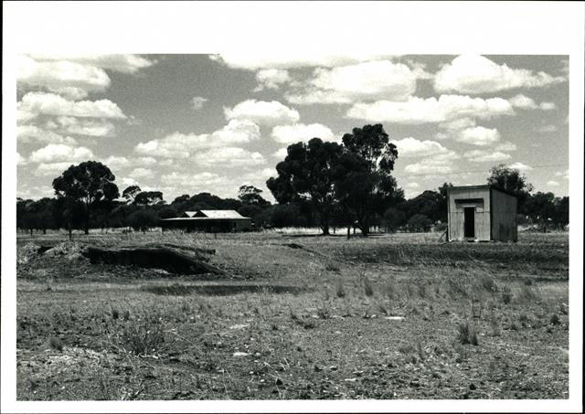 Loading ramp and shed in foreground, solitary remaining building in the backgrou