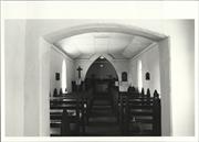 Interior elevation facing the altar and cross with pews in the foreground, throu
