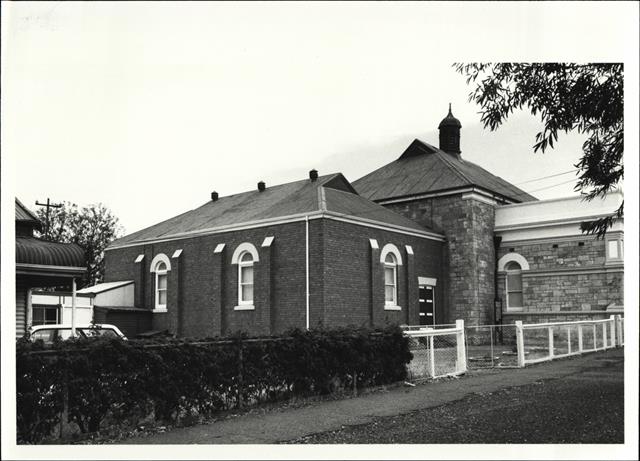 Corner elevation of building showing later red brick addition on South west side