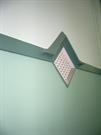 Interior wall vent and painted mouldings of the nave