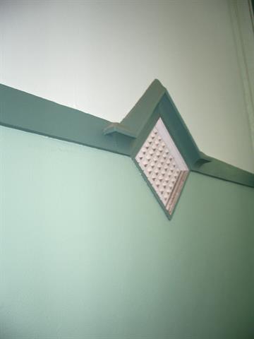 Interior wall vent and painted mouldings of the nave
