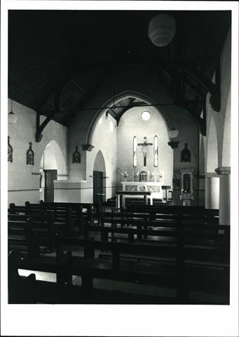 Interior angle view with pews in foreground looking towards the altar