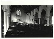 Angled interior view from entrance looking over pews