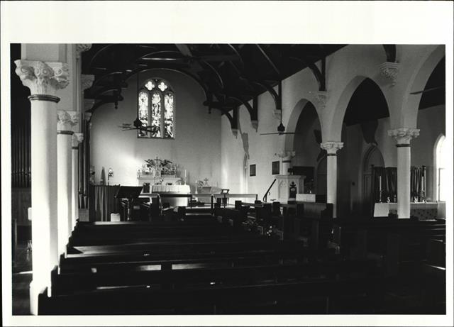 Angled interior view from entrance looking over pews