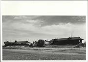 Distant corner elevation of old and later grandstands from racetrack