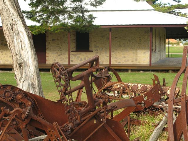 Homestead in the background and extant machinery in the foreground