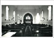 Interior landscape view with pews in the foreground looking towards the altar