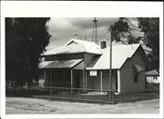 Angled front elevation of court house showing later wooden addition
