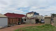 Rear view - tarping to second storey, damage to single storey roof