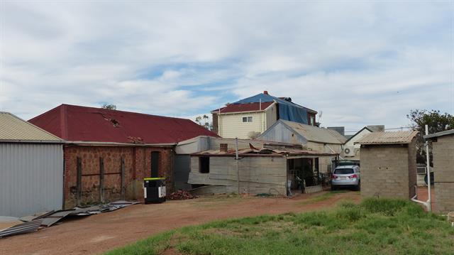 Rear view - tarping to second storey, damage to single storey roof