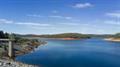 Serpentine Dam wall view over water body and tower