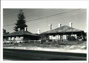 Front corner elevation of the Keeper's Cottages with the tip of Lighthouse visib