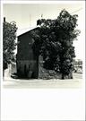 Angled front elevation of building (obscured by tree)