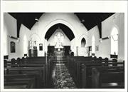Interior view of church from entrance showing altar in background and pews in fo