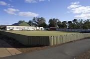 Front elevation of bowling pavilion with bowling green in foreground