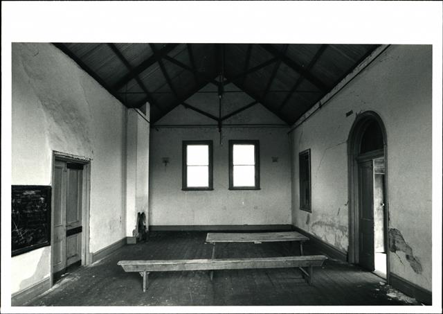 Interior view of Winnejup hall, bench and table in the foreground, looking towar