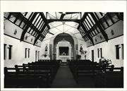 Interior view of church from main entrance showing pews altar and ceiling beams