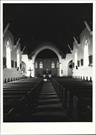 Interior view from entrance showing altar in background and pews in foreground
