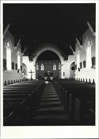 Interior view from entrance showing altar in background and pews in foreground