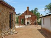 View of inn ruin between schoolhouse (l) and homestead (r)