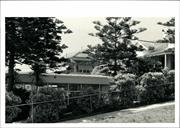 Front corner elevation, obscured by vegetation