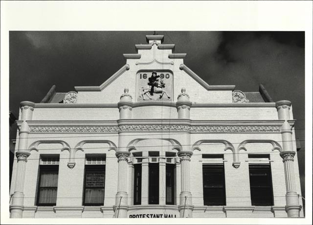 View of building façade showing plaque on pediment