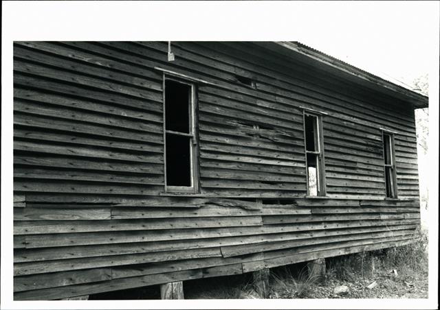 Side view of building showing deteriorating state of woodwork